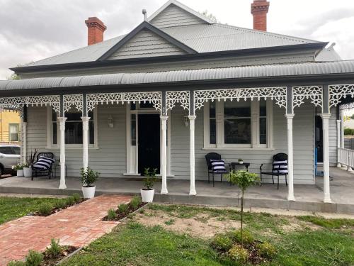 a white porch with chairs on a house at Daisy Cottage, 4 bedrooms, close to CBD in Golden Square
