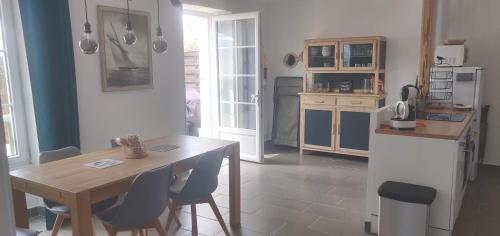 - une cuisine avec une table, une table et des chaises dans l'établissement Appartement duplex sur terrasse - 62m2, à Batz-sur-Mer