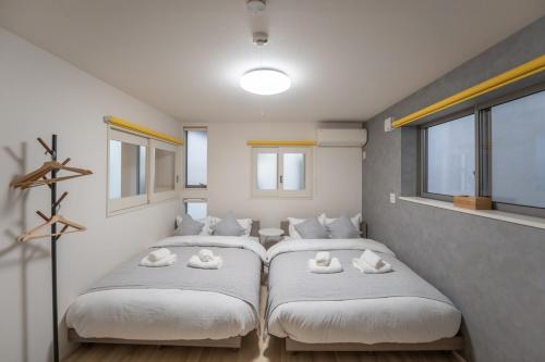 two beds in a room with white pillows at 恵比寿駅徒歩5分 貸切一軒家 in Tokyo