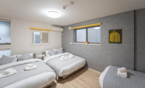 a bedroom with two beds and two windows at JR EBISU walk for 5min in Tokyo