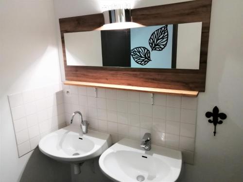 een badkamer met een wastafel en een spiegel bij La Roselière in Mérindol