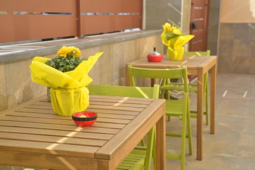 two tables and chairs with yellow flowers on them at La Casa di Eva in Brindisi