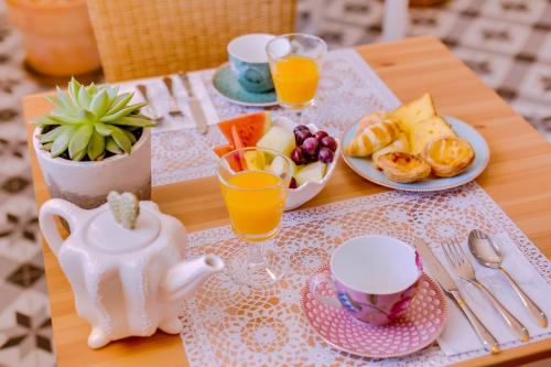 a table with a breakfast of fruit and orange juice at Quinta Almargem Lusitano - Farm House in Tavira