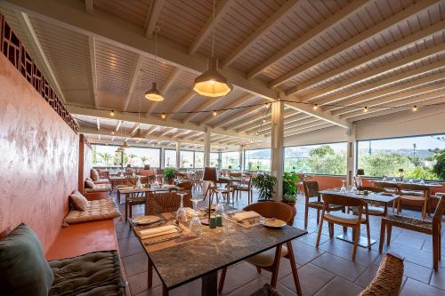 a restaurant with tables and chairs and windows at Akti Coast Club in Marmari