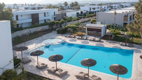 an overhead view of a swimming pool with umbrellas at Akti Coast Club in Marmari