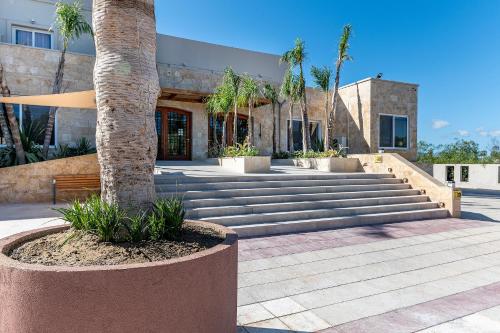 a palm tree in front of a building with stairs at Akti Coast Club in Marmari