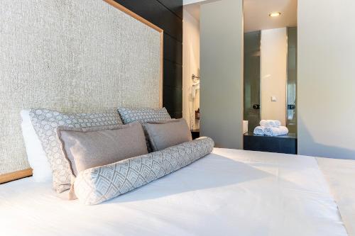 a bedroom with a white bed with pillows on it at Akti Coast Club in Marmari
