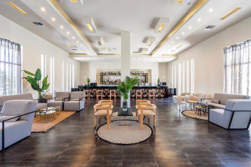 a lobby with chairs and tables and a bar at Akti Coast Club in Marmari