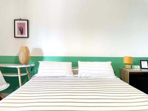 a bedroom with a bed with a green wall at Botanea Guest House in Fonte Nuova