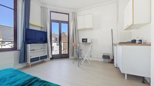 Cette chambre comprend un lit, une télévision et une fenêtre. dans l'établissement L'opale, studette 4, à Berck-sur-Mer