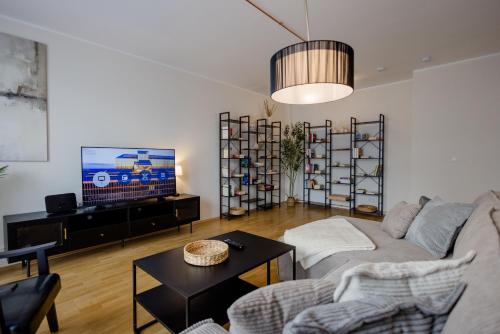 慕尼黑Lumen Homes - Altstadt-Residenz, direkt im Zentrum, geräumiges Apartment mit 5 Zimmern, Küche的客厅里有一张沙发和一台电视