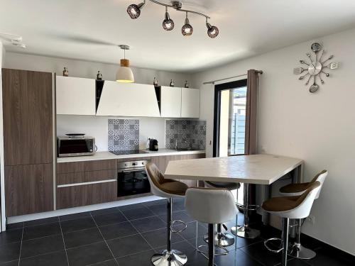 a kitchen with a table and chairs in a room at 9D - appartement Bonifacio Corse in Bonifacio