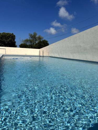 une piscine d'eau bleue en face d'un mur dans l'établissement 9D - appartement Bonifacio Corse, à Bonifacio