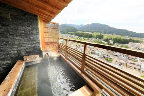 a hot tub on the balcony of a building at Ryokan Biyunoyado in Yamanouchi