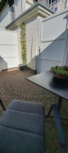 a patio with a fence and a table with a plant at De beukenboom Bed and Breakfast in Geleen