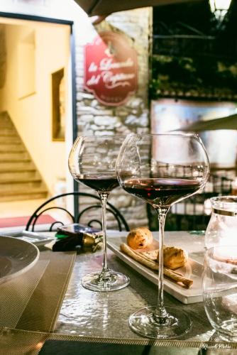 two glasses of wine sitting on a table at La Locanda Del Capitano in Montone