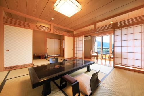 a room with a table and chairs and windows at Ryokan Biyunoyado in Yamanouchi