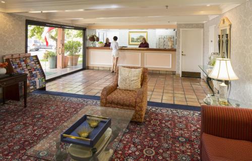 a living room with a person standing in the kitchen at Campbell Inn Hotel in Campbell