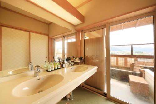 a bathroom with two sinks and a large window at Ryokan Biyunoyado in Yamanouchi