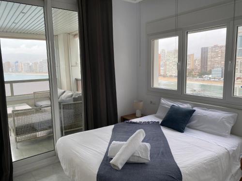 a bedroom with a bed with a large window at Excellent apartment in front of the sea! in Benidorm