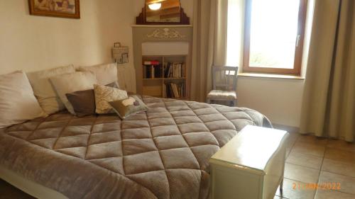 a bedroom with a large bed and a window at La ferme de la Cavalerie in Saint-Gonnery