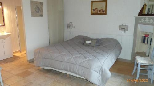 a bedroom with a bed and a chair at La ferme de la Cavalerie in Saint-Gonnery