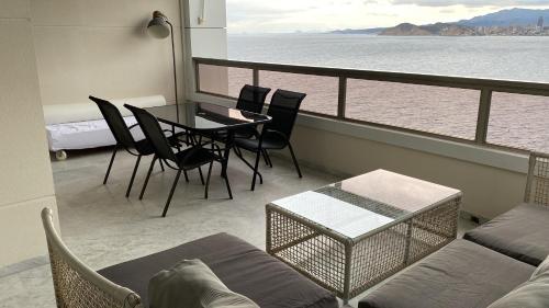 a living room with a table and chairs on a balcony at Excellent apartment in front of the sea! in Benidorm