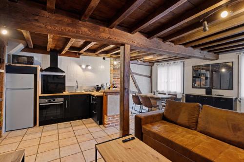 un salon avec un canapé et une cuisine dans l'établissement Les chambres Tonics, à Montrevel-en-Bresse