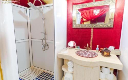 bagno con doccia, lavandino e specchio di Merzouga Luxury Camp a Merzouga