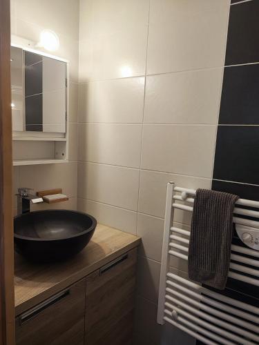 a bathroom with a black bowl sink on a counter at Quiétude Vexinoise in Boury-en-Vexin