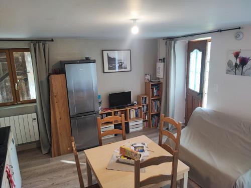 a living room with a table and a refrigerator at Quiétude Vexinoise in Boury-en-Vexin
