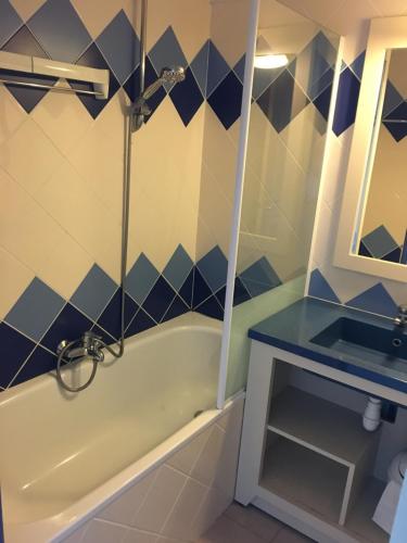 une salle de bain avec une baignoire et un lavabo dans l'établissement Appartement vue mer Audierne, à Audierne