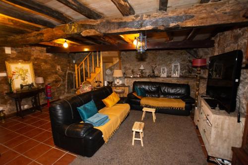 a living room with a leather couch and a table at Casa da Mata de Fajão in Pampilhosa da Serra
