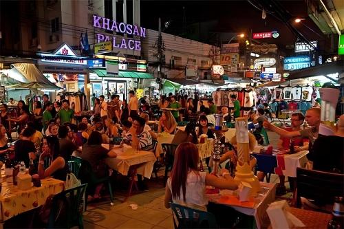 a crowd of people sitting at tables in a street at night at XX GO INN Khaosan - ตรอกข้าวสาร กรุงเทพ in Bangkok
