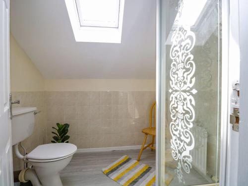 a bathroom with a toilet and a glass shower door at The Old Surgery in Grange Over Sands