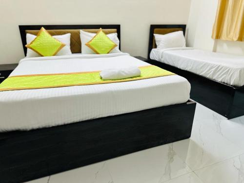 two beds in a hotel room with towels on them at S V COMFORTS B T M Layout in Bengaluru