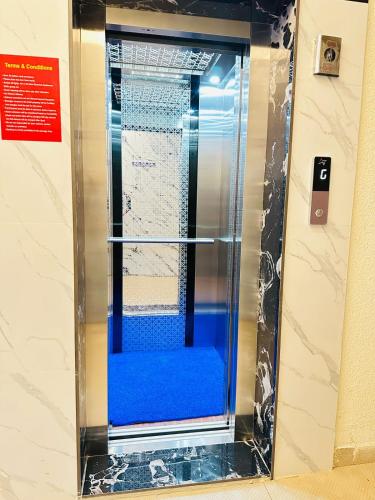 a glass shower with a blue seat in a bathroom at S V COMFORTS B T M Layout in Bengaluru