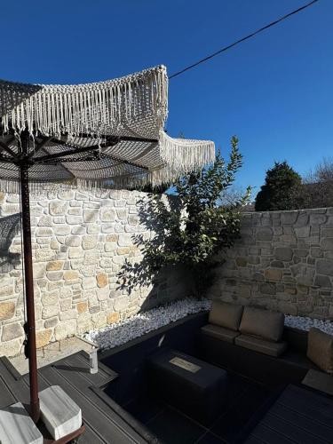 a patio with a couch and an umbrella and a stone wall at Prime Suites in Kadıköy