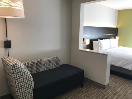 a hotel room with a bed and a chair at Holiday Inn Express & Suites - Prospect Heights by IHG in Prospect Heights