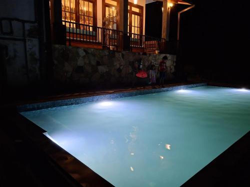a swimming pool at night with a frisbee in it at Dew Drops Nature Villa in Parakaduwa
