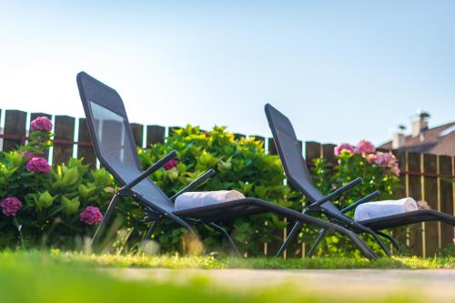 a group of chairs sitting in the grass at Apartments Villa Vardia in Caldaro
