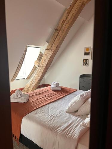 a bedroom with a large bed with a window at Les Chambres du parc in Monnières