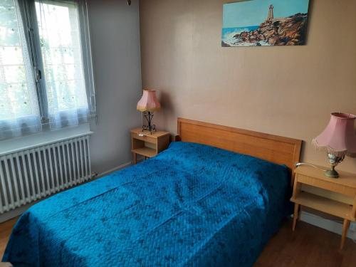 - une chambre avec un lit bleu et 2 tables de chevet dans l'établissement Family house for 7, à Perros-Guirec