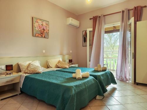 Un dormitorio con una cama con una manta verde y una ventana. en Condesa Apartments, en Sidari