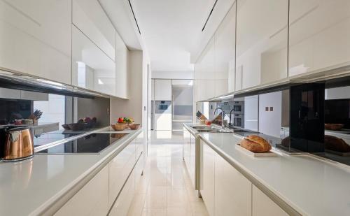 a large white kitchen with white cabinets and appliances at Mandarin Oriental, Doha in Doha