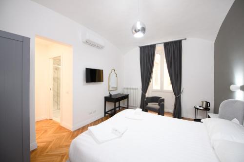 a white bedroom with a bed and a desk and a room at Boncompagni Serenity Suites in Rome