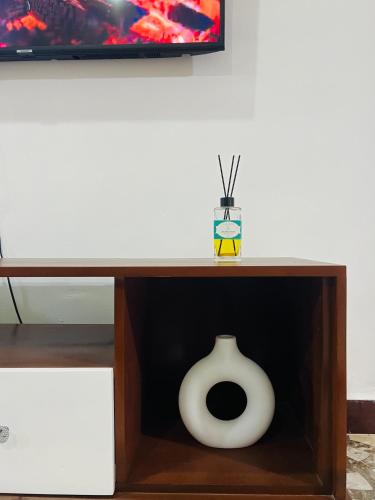 a wooden table with a white vase in a drawer at The Luxe Apartment in Zanzibar City