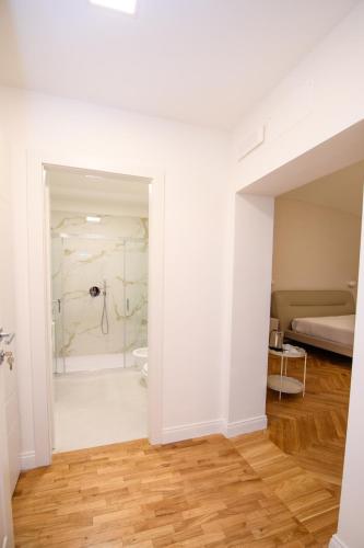 a white bathroom with a shower and a bed at Boncompagni Serenity Suites in Rome