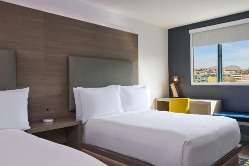 a hotel room with two beds and a window at Aloft Scottsdale in Scottsdale