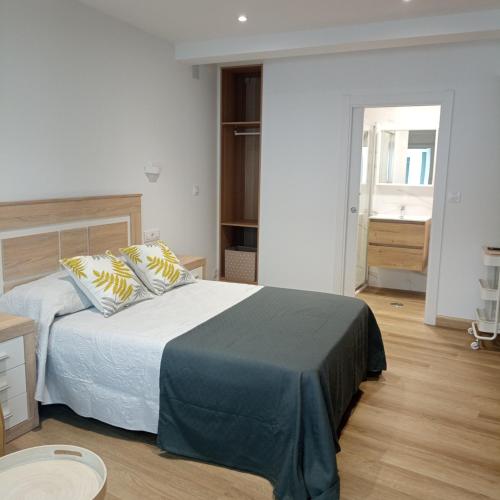 a bedroom with a bed and a room with a window at Casa Jesús in Muxia